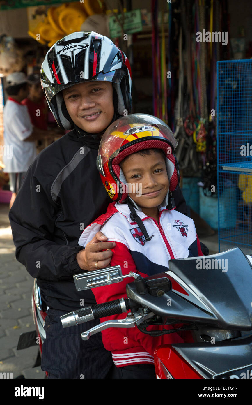 Yogyakarta, Java, Indonesien.  Zwei junge Männer mit Helmen auf einem Motorrad, Vogelmarkt. Stockfoto