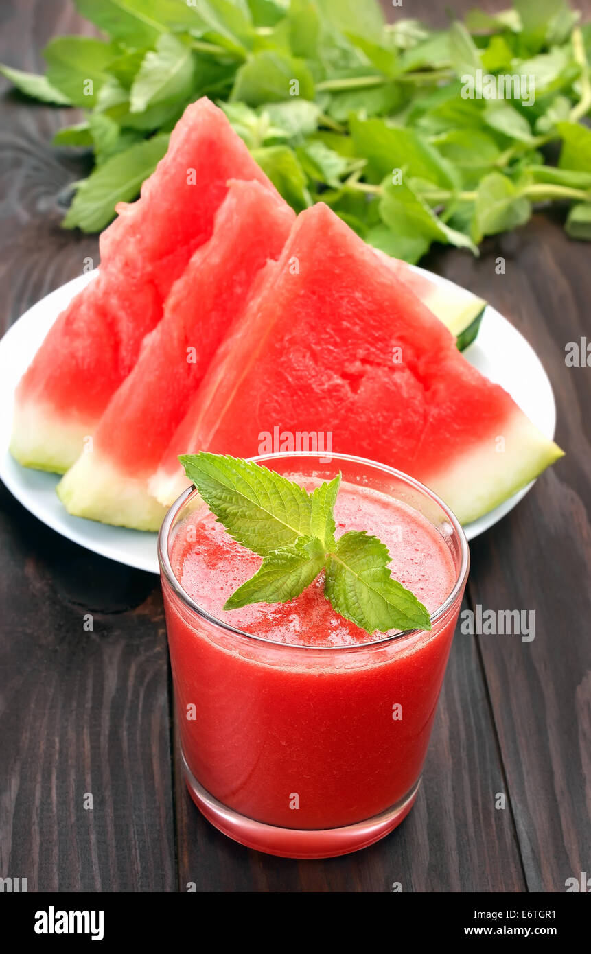 Wassermelone mit Minze im Glas und Wassermelone Scheiben auf Holztisch cocktail Stockfoto