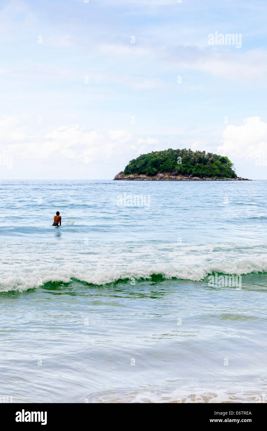 Eine Surfer wartet auf eine Welle am Kata Beach, Phuket, Thailand Stockfoto