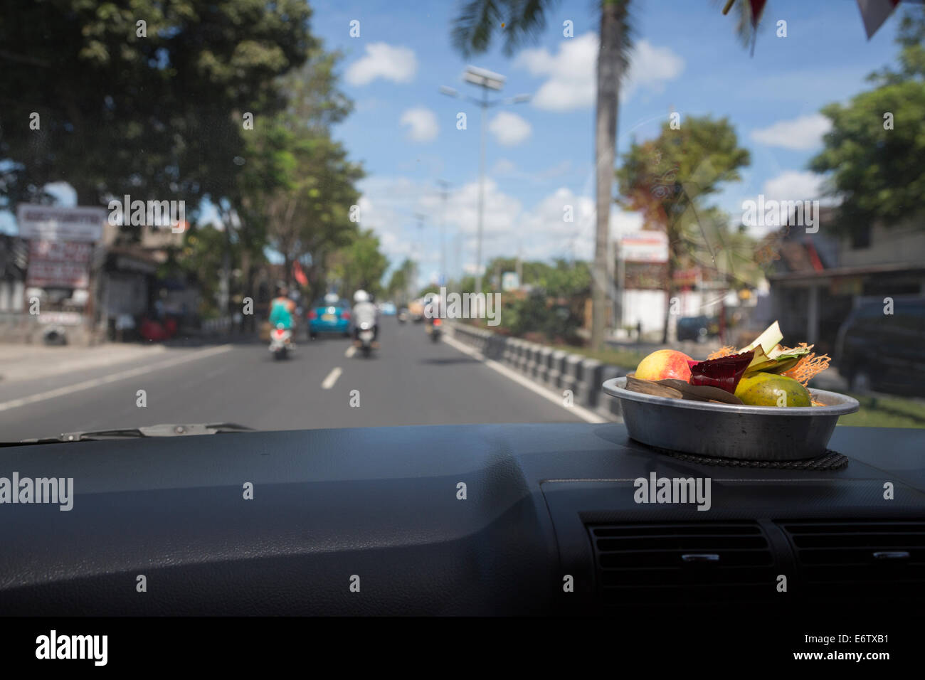 Bali, Indonesien.  Ein Canang, eine balinesische Gabe an die Götter auf dem Armaturenbrett eines privaten Autos. Stockfoto