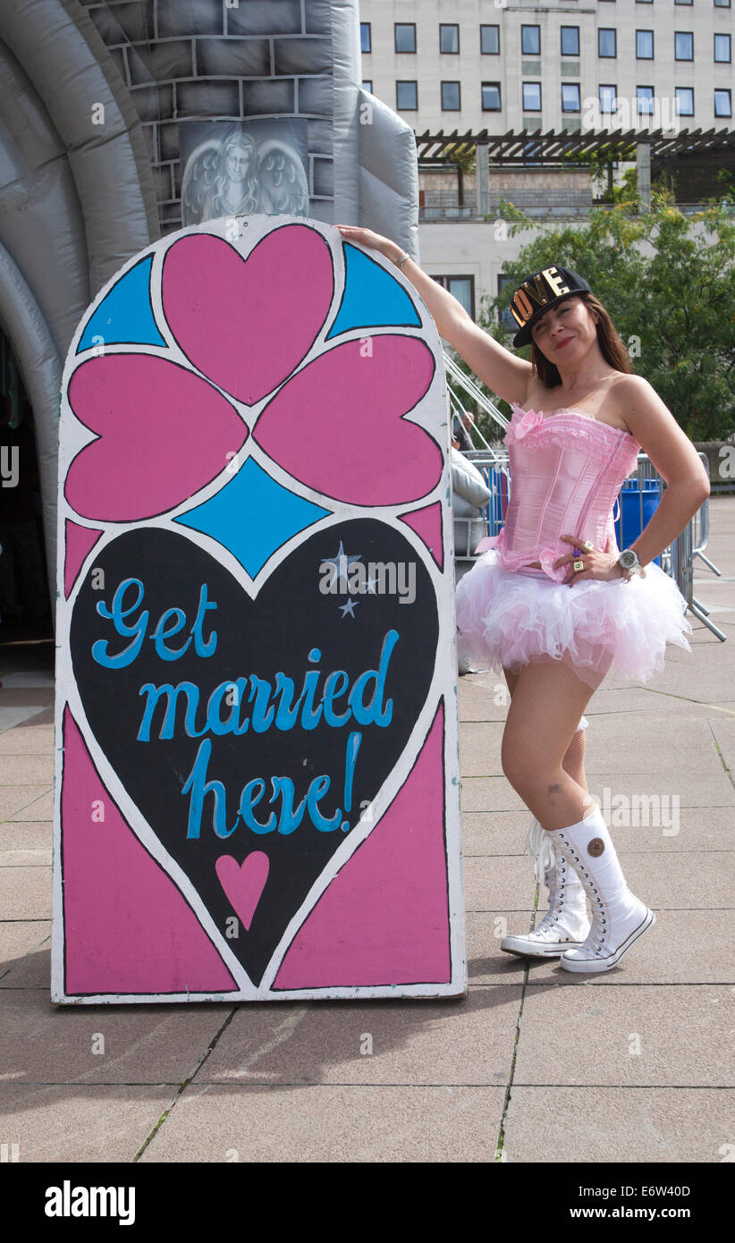 "Get heiratete hier" Zeichen und Festival-Teilnehmer außerhalb der aufblasbaren Hochzeitskapelle im Rahmen des "Festival of Love" Wochenendes an Londons South Bank - Kredit-Samstag, 30. August 2014: Neil Setchfield/Alamy Live News Stockfoto