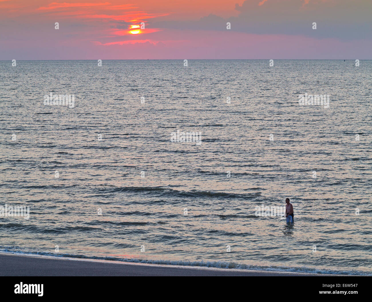 Einsame Paddler in einem kalten grauen Meer bei Sonnenuntergang Stockfoto