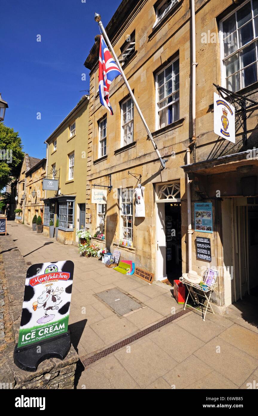 Union Jack-Flagge auf einem Fahnenmast befestigt die Wand eines Shops entlang der Hauptstraße, Chipping Campden, England, UK. Stockfoto