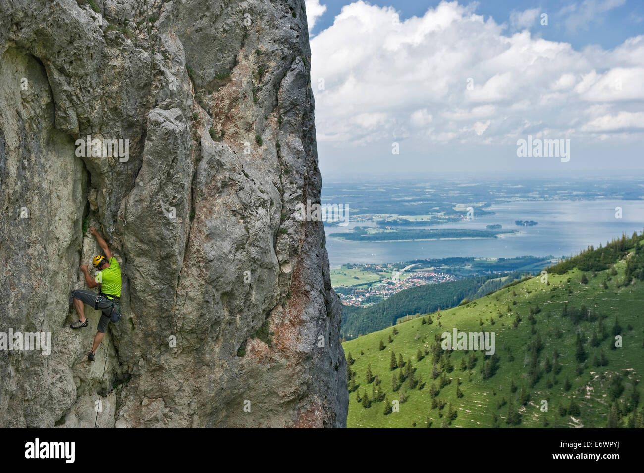 Kletterer aufsteigender Kampenwand, See Chiemsee im Hintergrund, Chiemgau, Bayern, Deutschland Stockfoto
