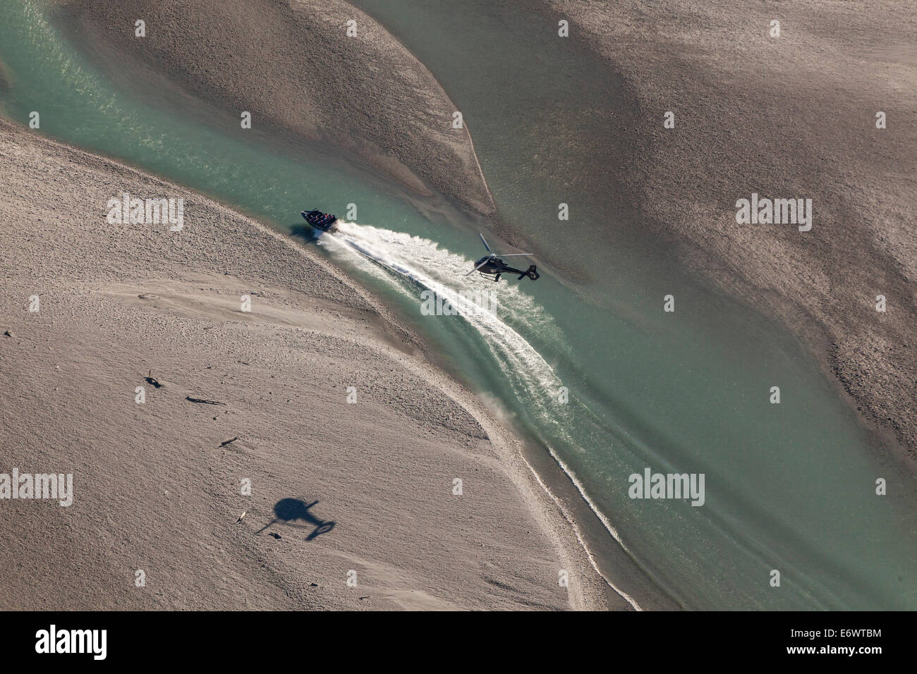 Luftaufnahme von einem Jetboat Beschleunigung in einem Fluss, gefolgt von einem Hubschrauber, Queenstown, Otago, Neuseeland Stockfoto