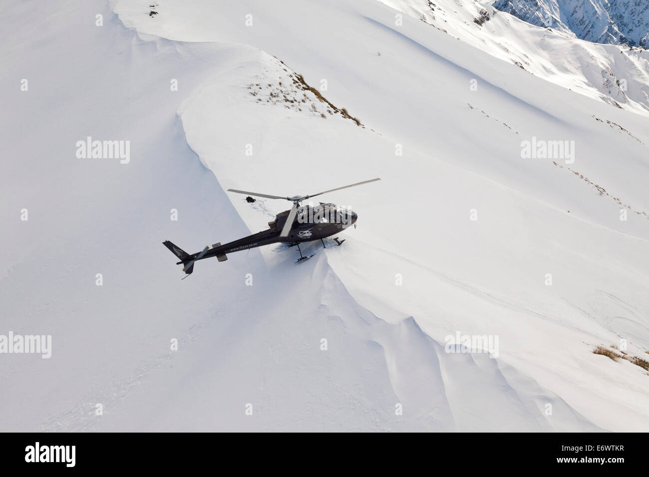 Hubschrauberlandeplatz mit Skifahrer und Snowboarder im tiefen Schnee, Wintersport, Heliskiing, Südinsel, Neuseeland Stockfoto