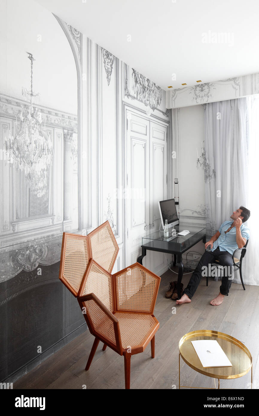 Mann sitzt an einem Schreibtisch in einer Hotelsuite, Paris, Frankreich Stockfoto