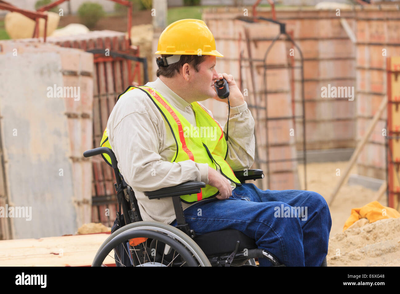 Bauleiter mit Spinal Cord Injury auf Walkie-Talkie Inspektion Betonfundament Formen Stockfoto