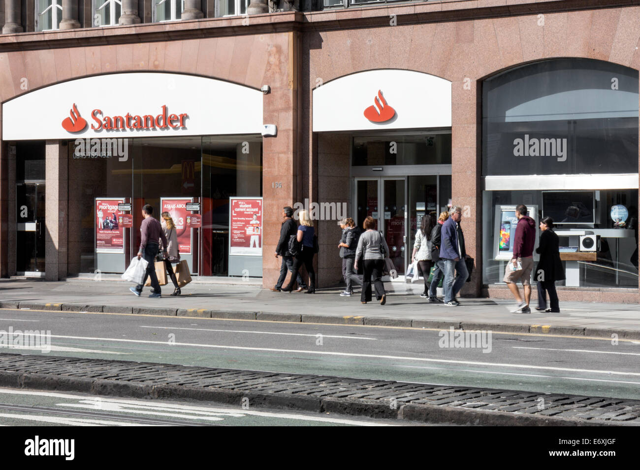 Käufer zu Fuß vorbei an Santander Bank auf Princes Street, Edinburgh Stockfoto