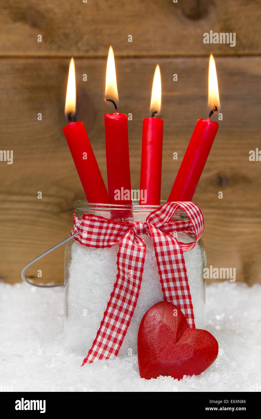 Weihnachtskarte Vier Rote Brennende Kerzen Mit Schleife Und Herz Auf Schnee Auf Holzernen Hintergrund Stockfotografie Alamy