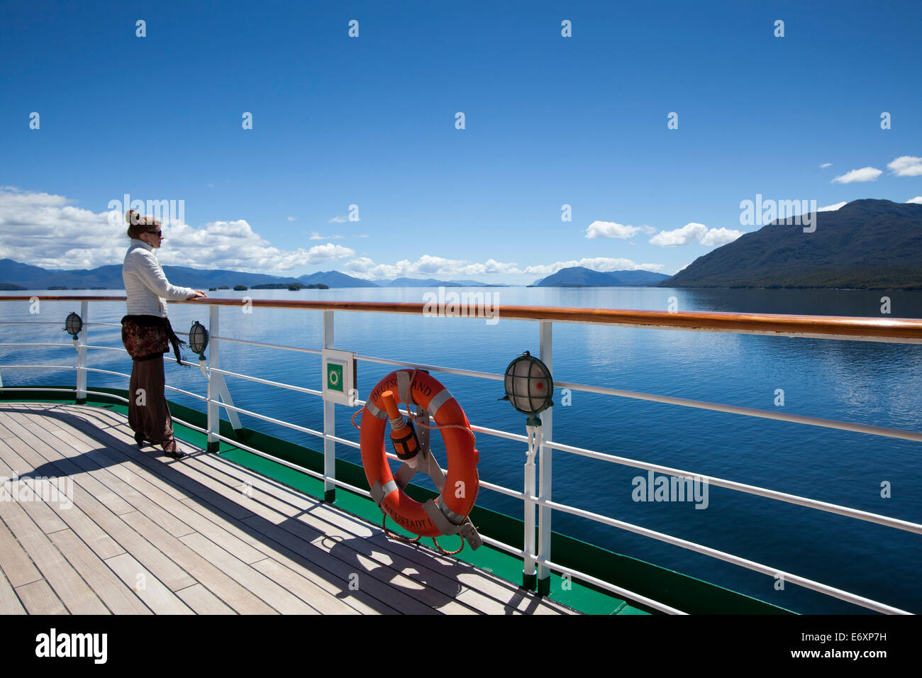 Frau an der Reling des Kreuzfahrtschiff MS Deutschland (Reederei Peter Deilmann), chilenische Fjorde, Magallanes y De La Antartica Chile Stockfoto