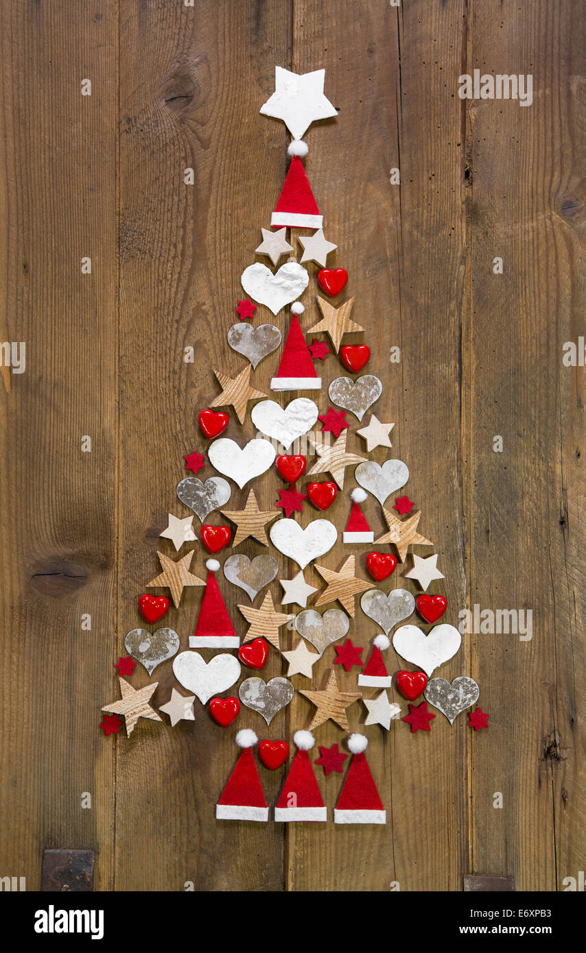 Weihnachtsbaum in roter und weißer Farbe auf einem hölzernen Hintergrund - Deko-Idee für advent Stockfoto