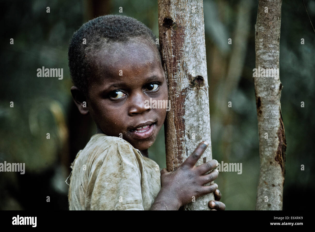 Junges Mädchen lehnte sich gegen einen Baum, Uganda, Afrika Stockfoto