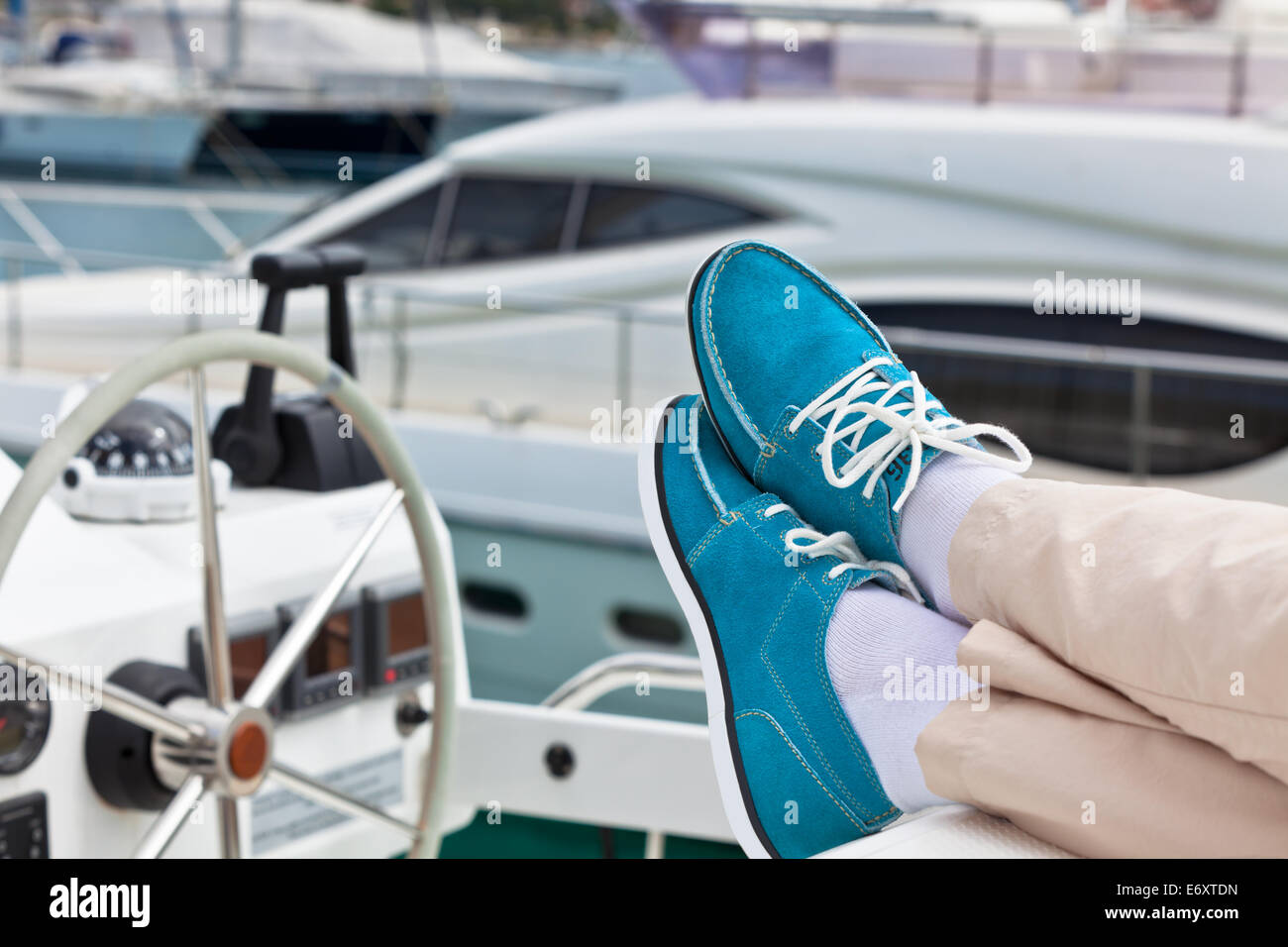 Ein paar menschliche Beine in Hosen und helle blaue Topsiders auf Yacht Hintergrund. Yachting Stockfoto