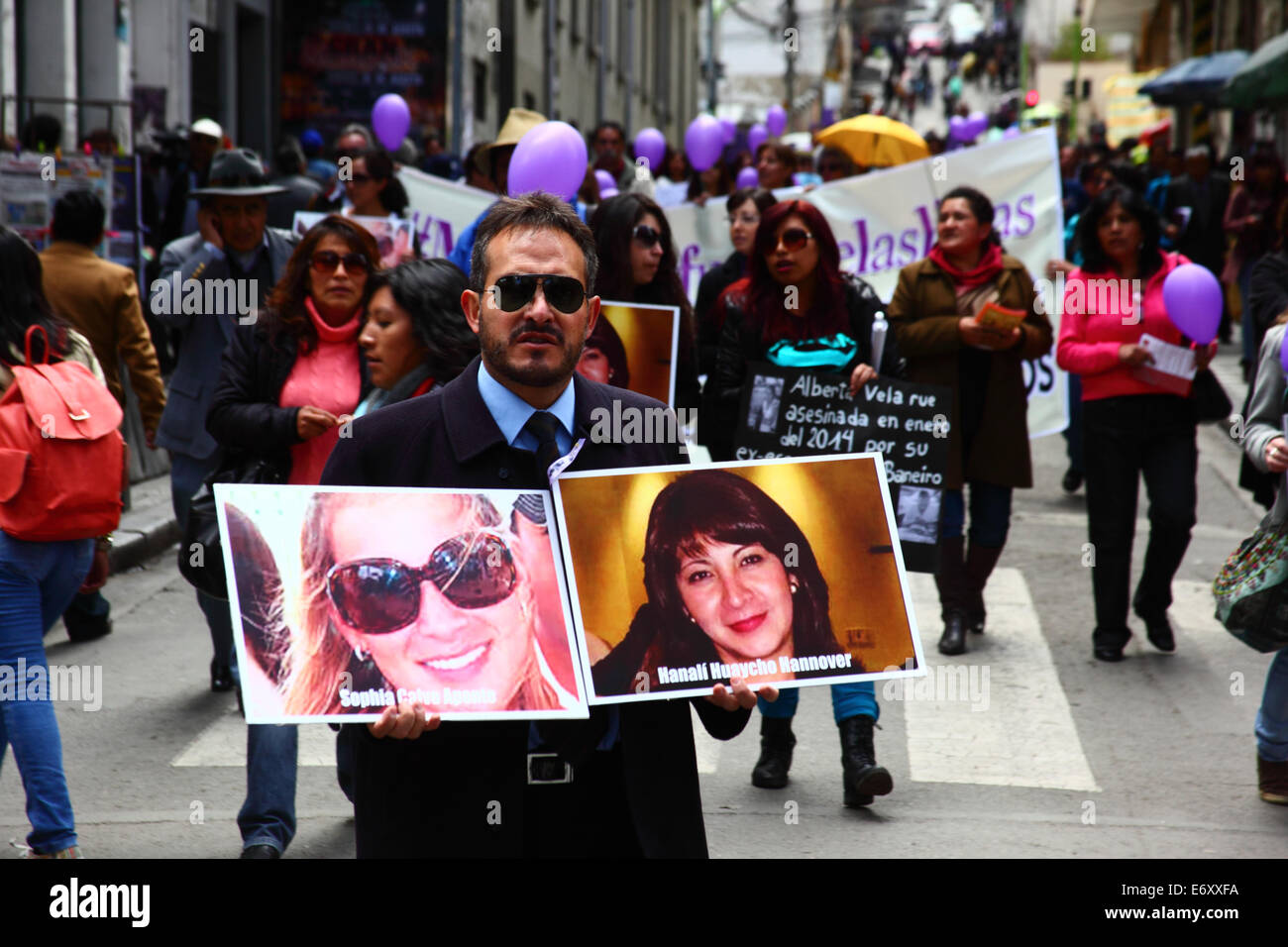 La Paz, Bolivien, 1. September 2014. Ein Mann hält Fotos von Opfern Sophia Calvo Aponte und Hanali Huaycho während eines Marsches zum protest gegen Gewalt gegen Frauen und Machismo. Der Marsch war auch die jüngsten Erklärungen mehrere politische Kandidaten im aktuellen Wahlkampf zurückweise, die angezeigt werden, das Problem zu minimieren. Laut einem Bericht der WHO im Januar 2013 Bolivien ist das Land mit der höchsten Rate der Gewalt gegen Frauen in Lateinamerika, wurden seit 2006 453 Fälle von Frauenmorde in der aktuellen Regierung. Bildnachweis: James Brunker / Alamy Live News Stockfoto