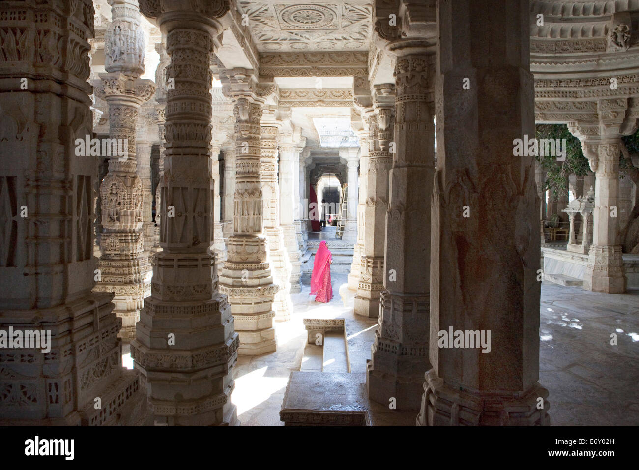 Indische Frau trägt Sari zwischen den Säulen des Jainist Haupttempels Chaumukha Mandir, Ranakpur, Rajasthan, Indien Stockfoto