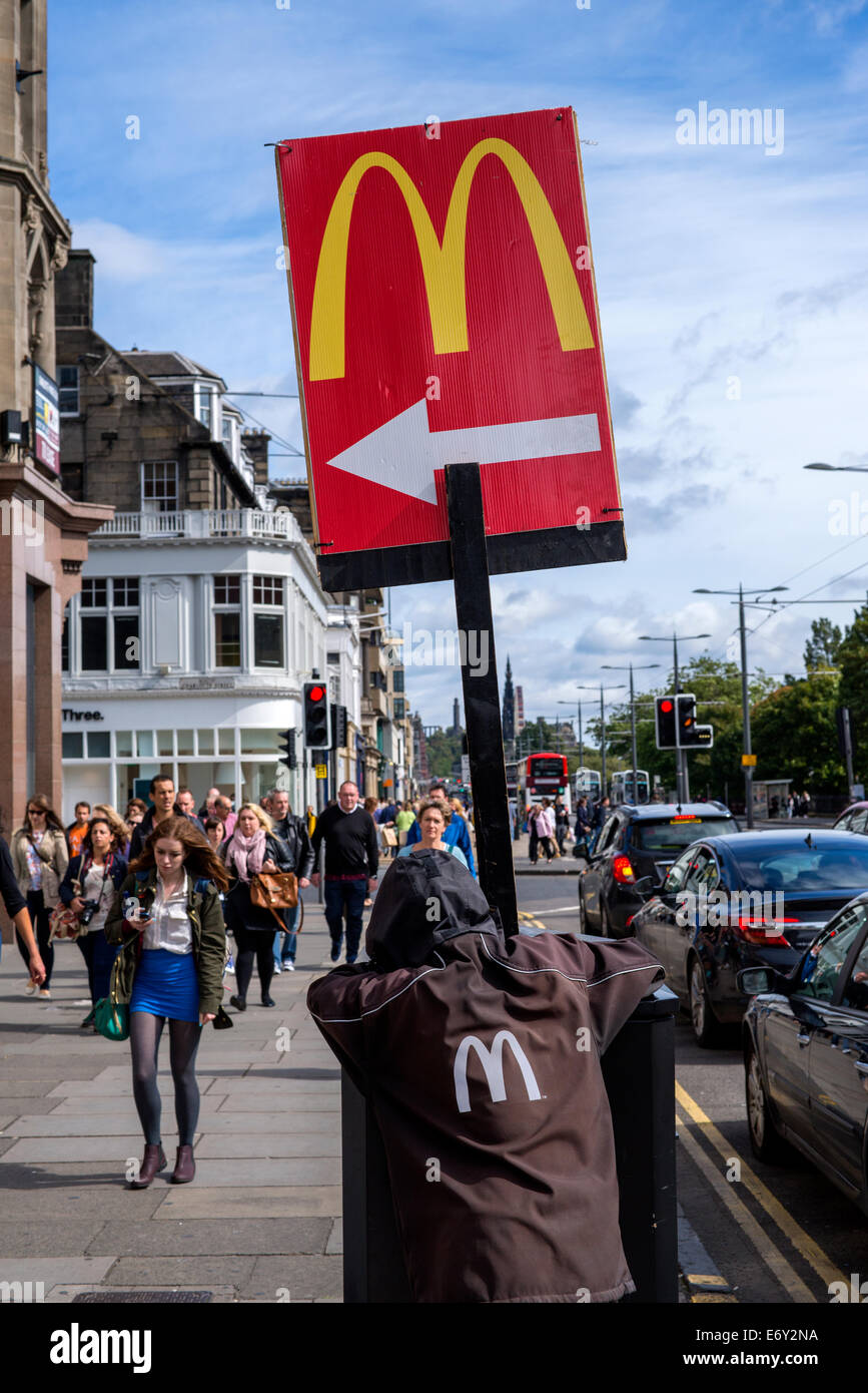 Nicht den besten Job der Welt, ein junger Mann hält das McDonalds-Schild auf Princes Street, Edinburgh, Scotland, UK. Stockfoto