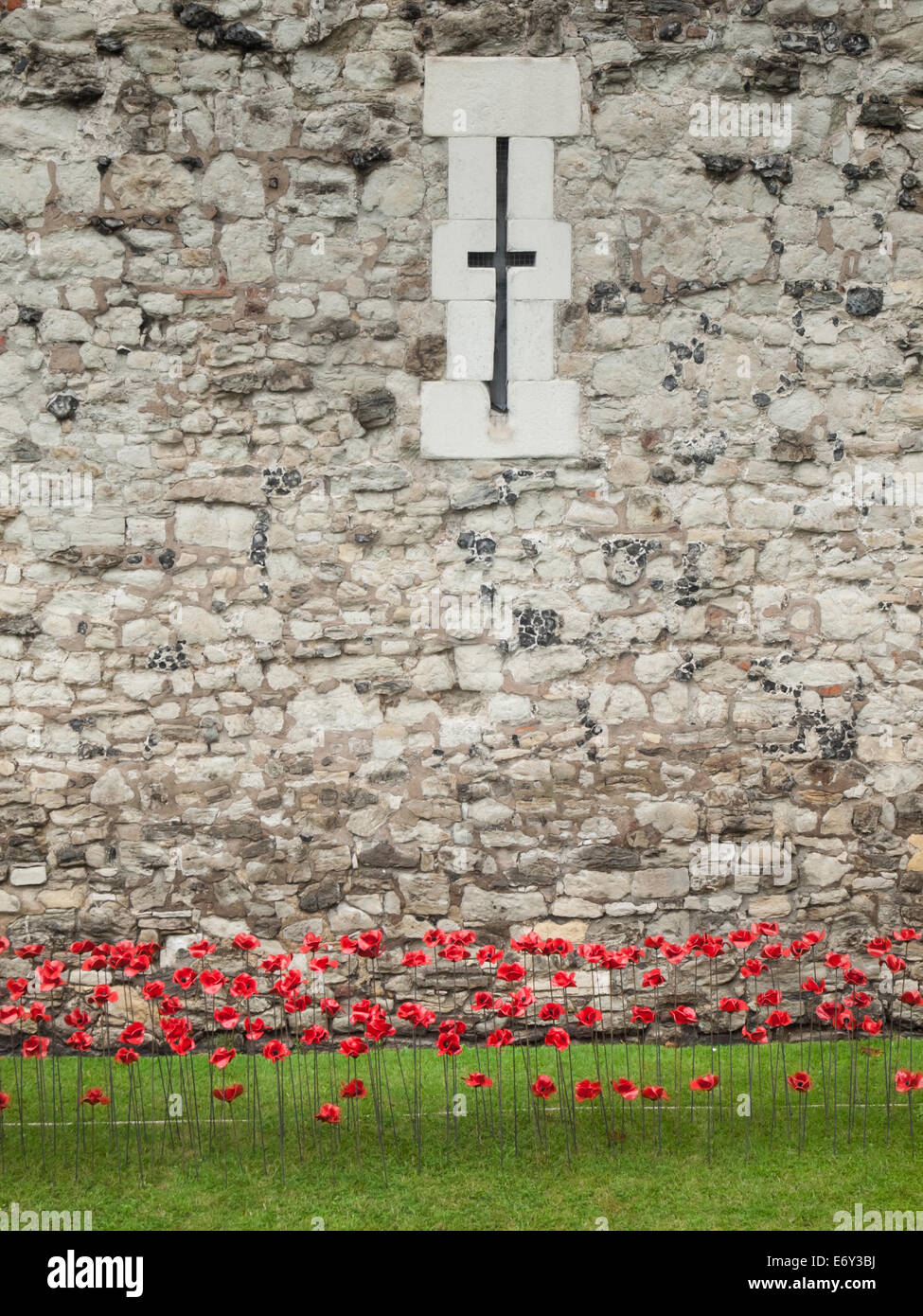 Detail der Keramik Mohnblumen-Ausstellung auf dem Tower of London bei starkem Regen mit der Turmwand hinter. Stockfoto