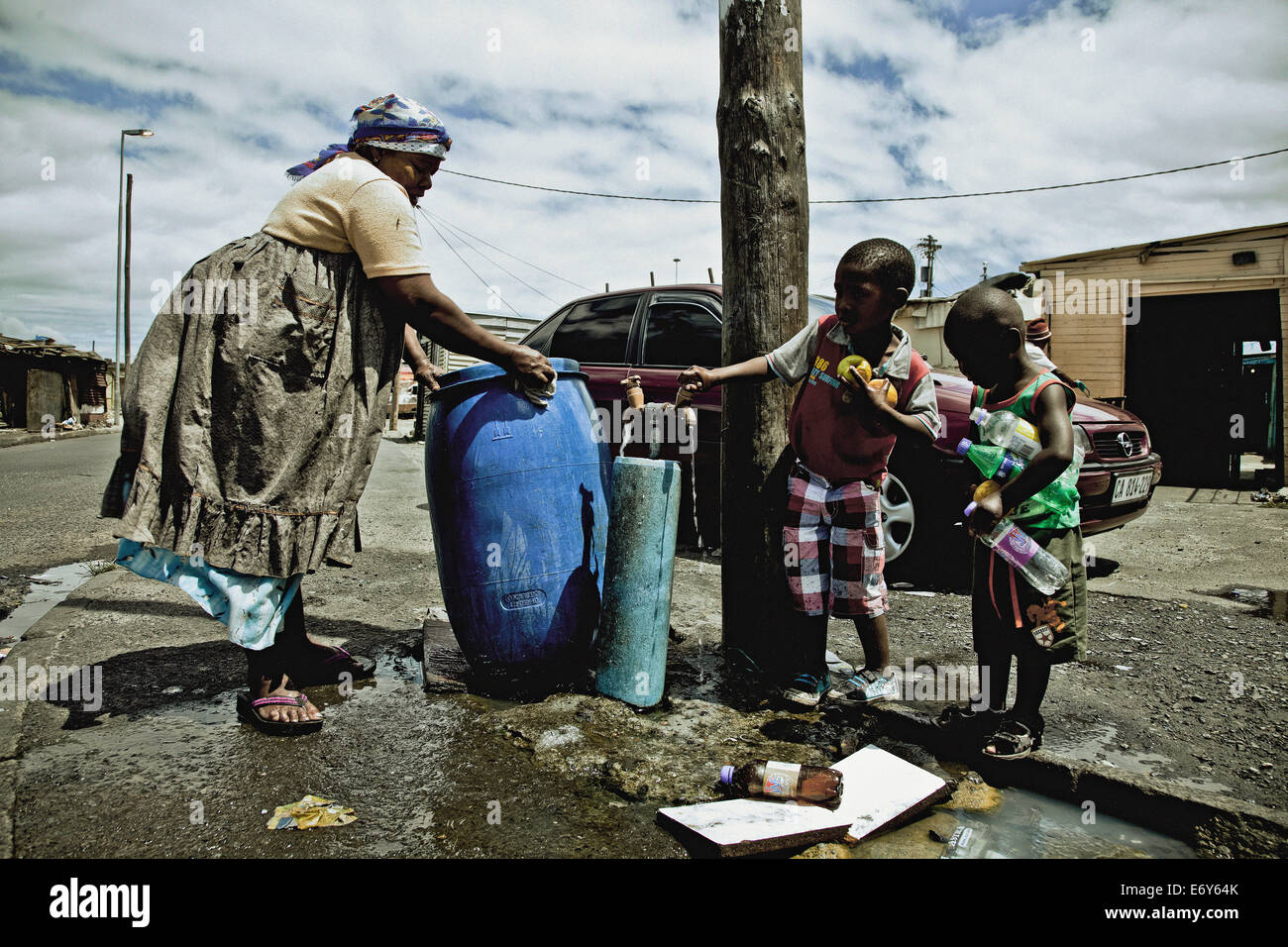 Eine Frau und zwei Kindern an die öffentliche Wasserversorgung Registerkarte Township Langa, Cape Town, Südafrika, Afrika Stockfoto