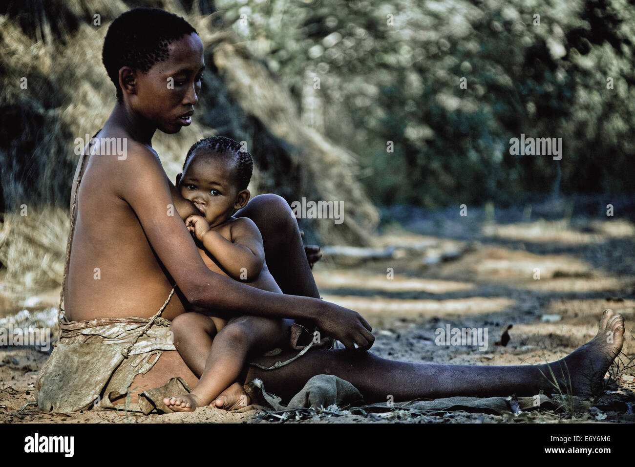 Mutter und Tochter des Stammes San sitzen auf dem Boden vor ihrer Hütte, Otjozondjupa Region, Namibia, Afrika Stockfoto