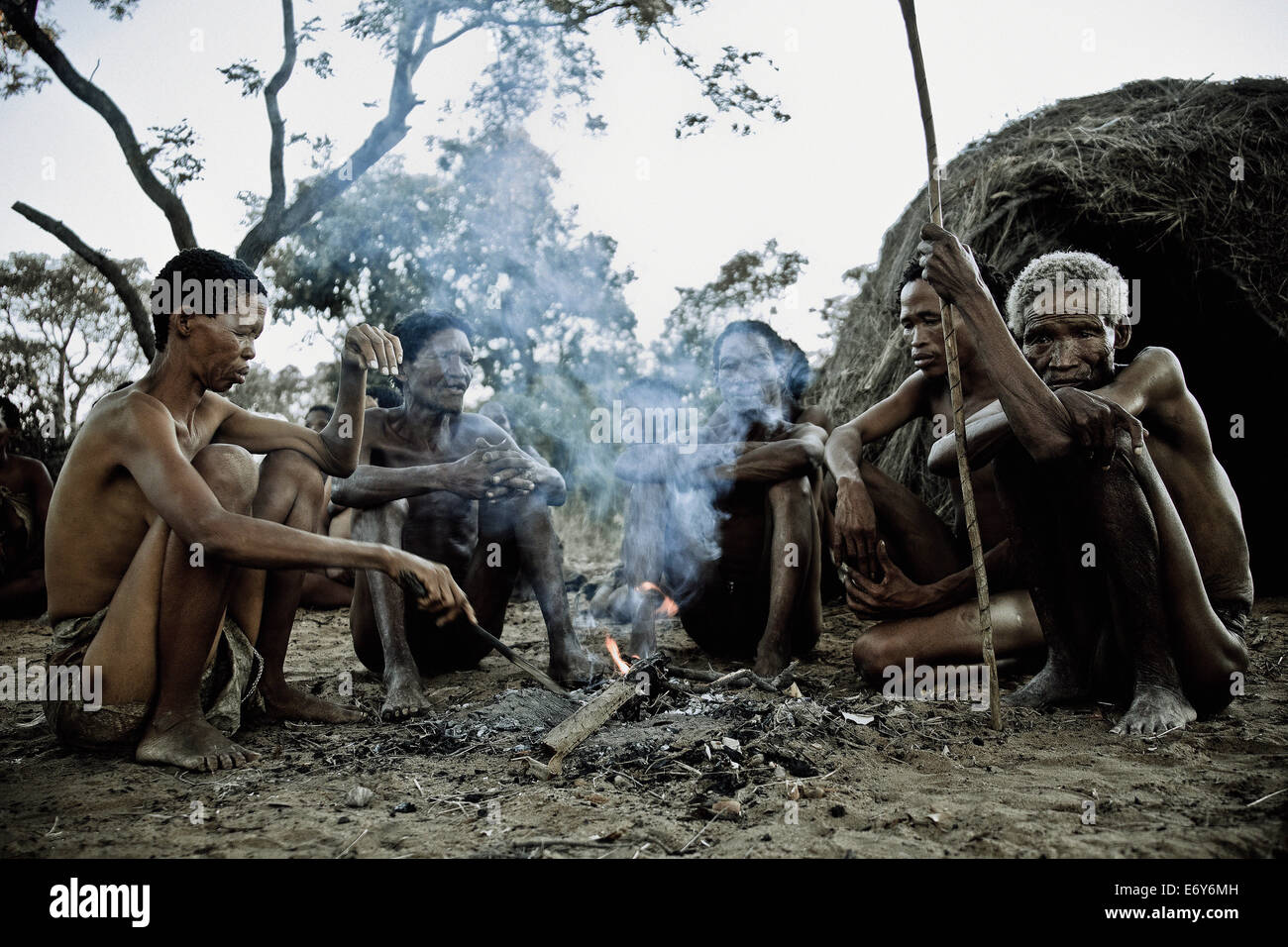 Eine Frau und vier Männer aus dem San-Stamm sitzen um ein Lagerfeuer, Otjozondjupa Region, Namibia, Afrika Stockfoto
