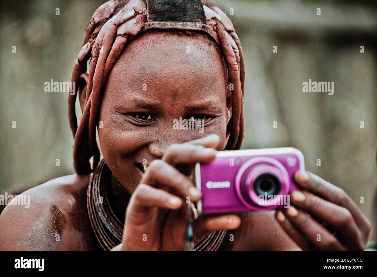 Frau des Stammes Himba hält eine moderne Kamera, Kaokoland, Namibia, Afrika Stockfoto