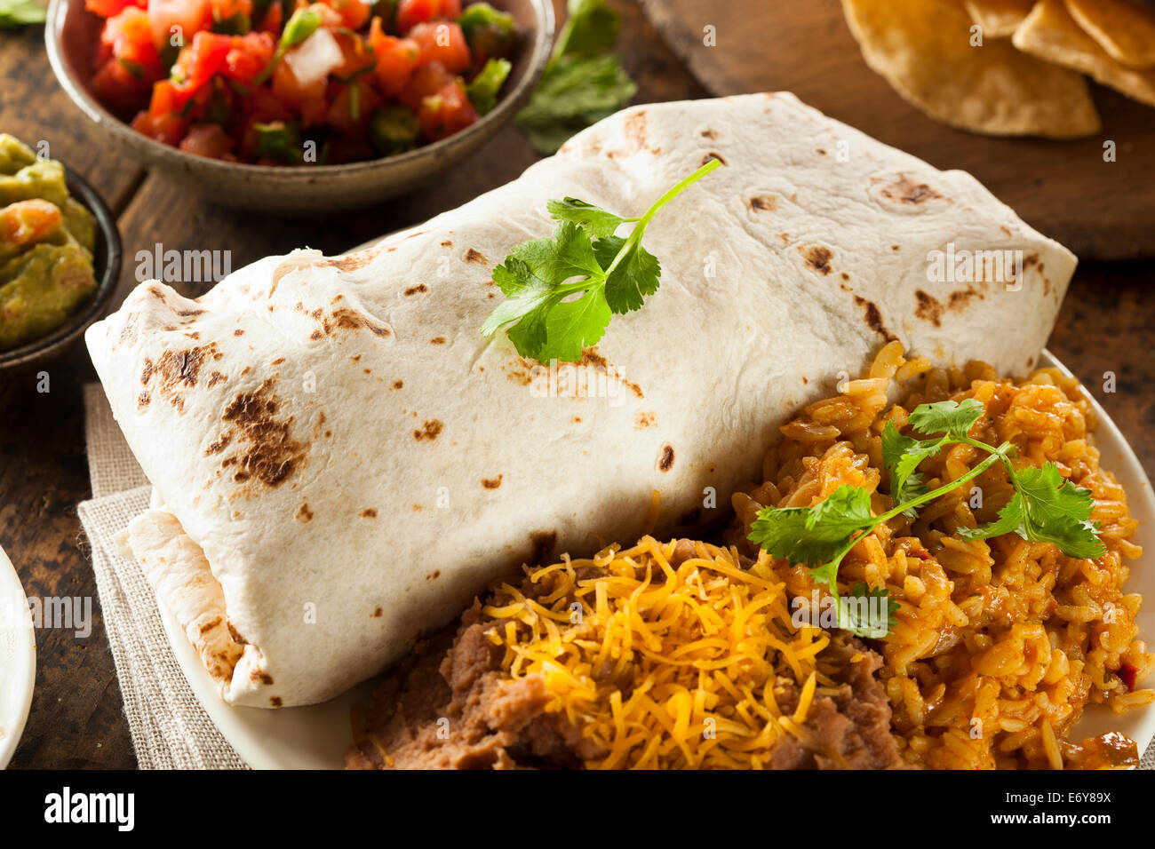 Hausgemachte Riesen Rindfleisch-Burrito mit Salsa Salat und Reis Stockfoto