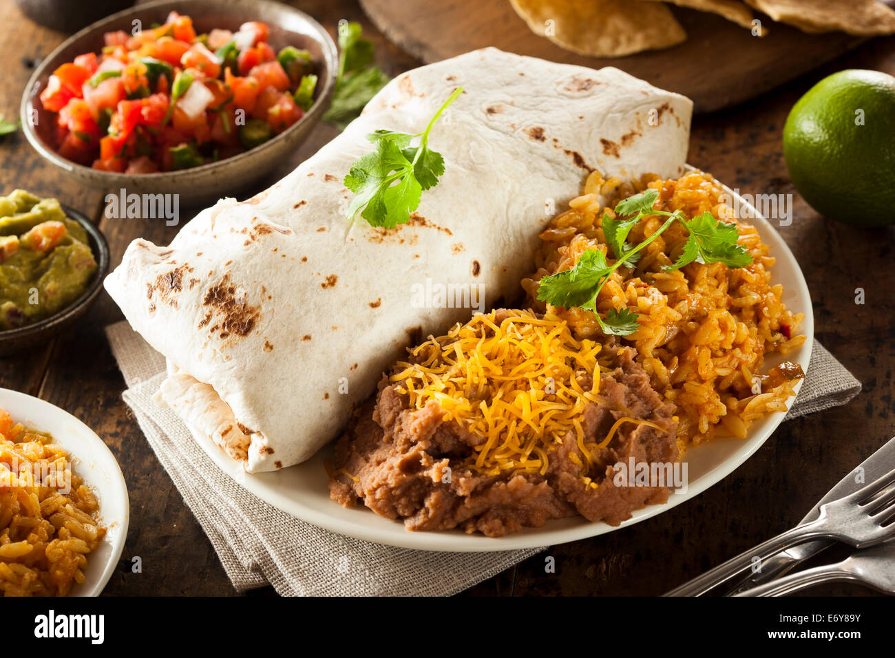 Hausgemachte Riesen Rindfleisch-Burrito mit Salsa Salat und Reis Stockfoto