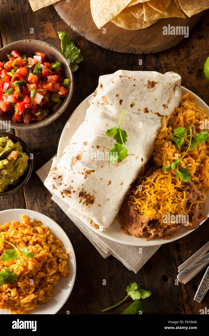 Hausgemachte Riesen Rindfleisch-Burrito mit Salsa Salat und Reis Stockfoto