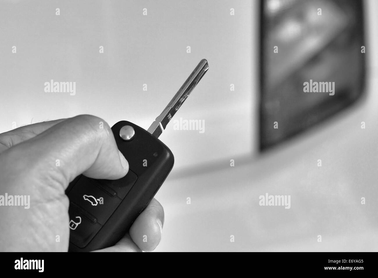 Nahaufnahme des Mannes Hand, die Fahrzeugschlüssel mit aus Focus Auto im Hintergrund Stockfoto