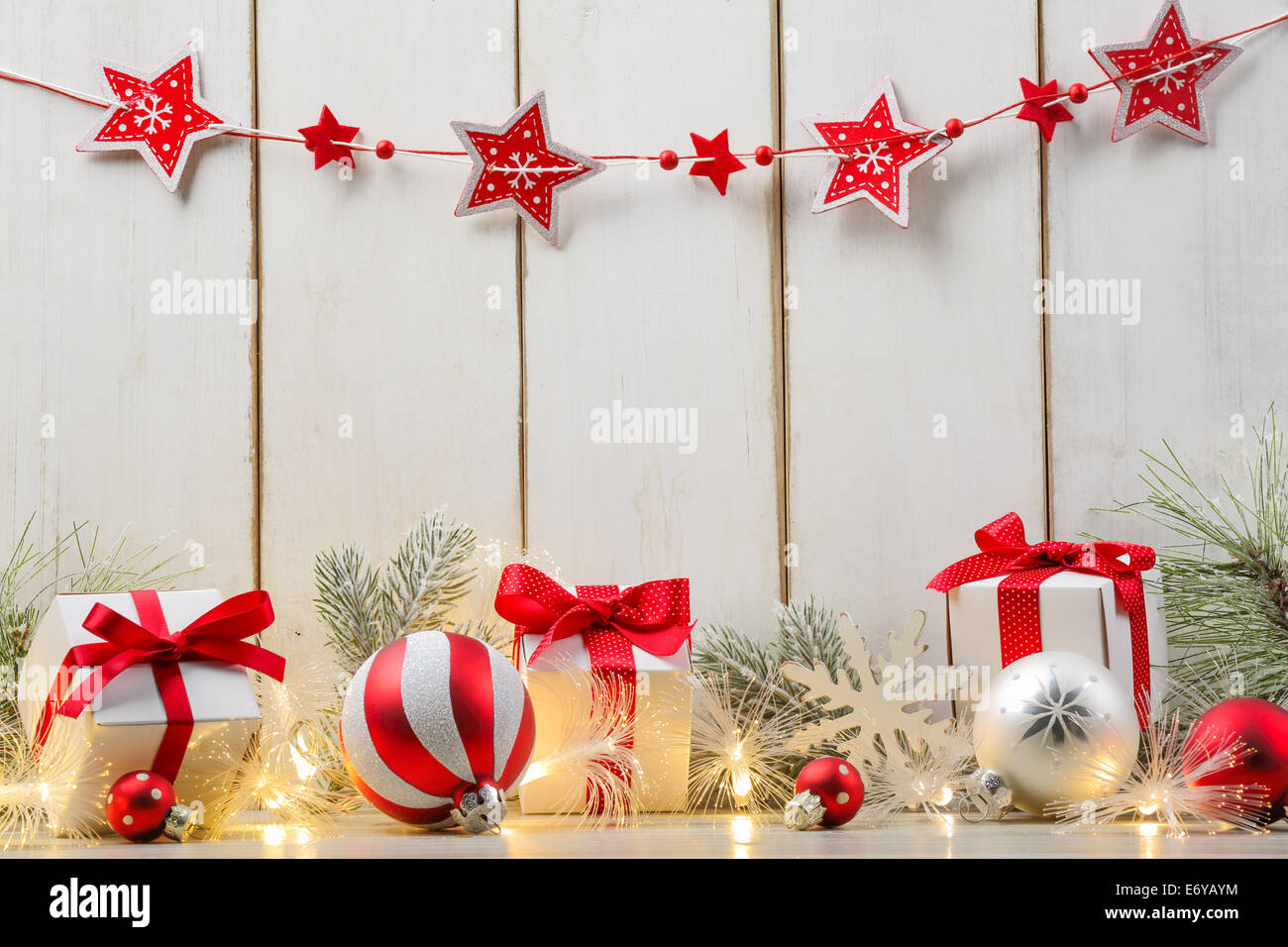 Weihnachtskugel, Geschenke, Tanne Zweig und Lichter auf Holzbrett. Stockfoto