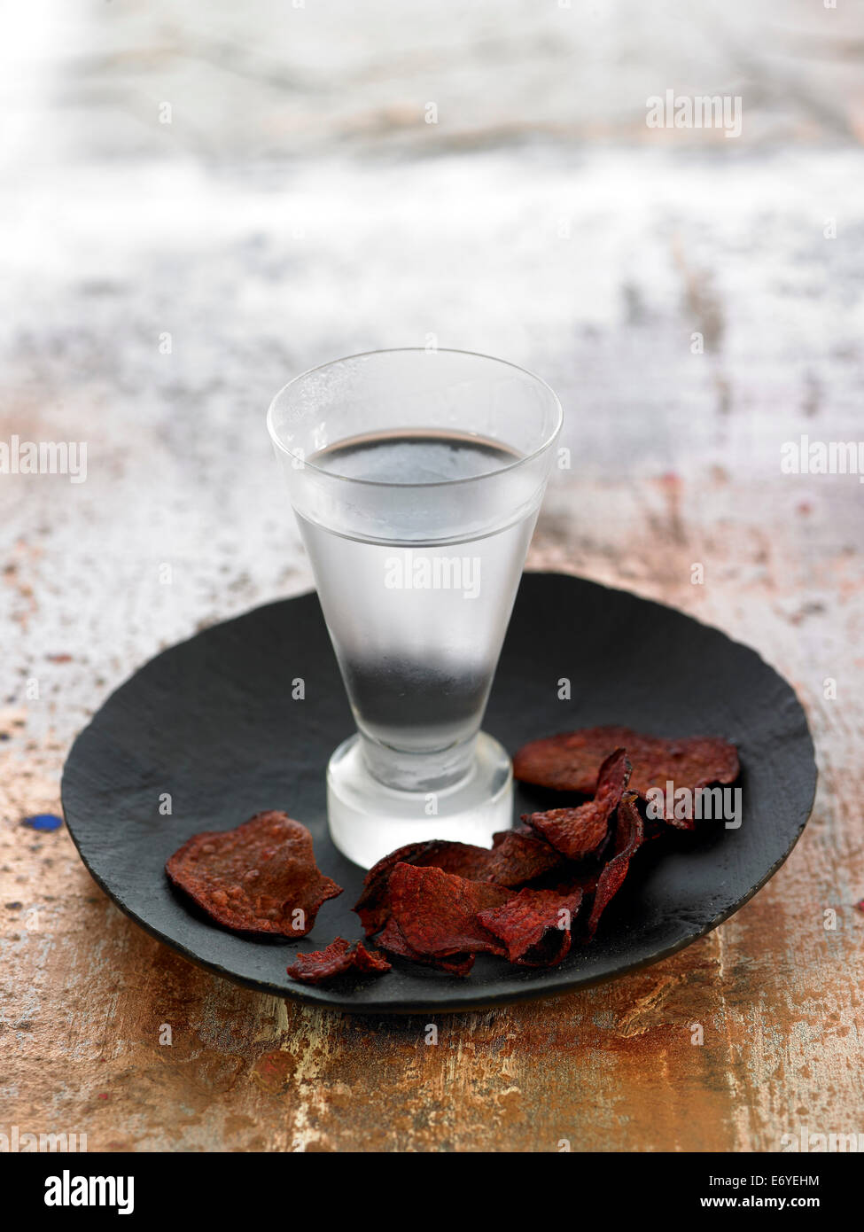 Glas von Gin und rote Beete Chips Stockfoto