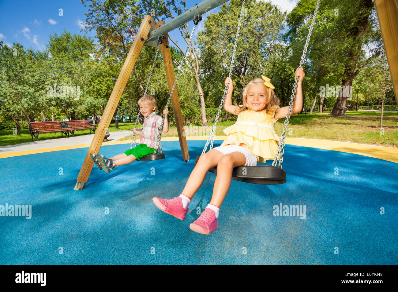 Zwei süße Kinder schwingen auf Spielplatz Stockfoto