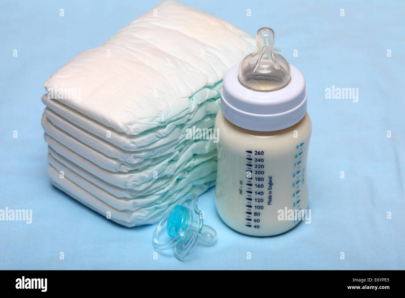 Baby-Flasche mit Milch, Windeln und Schnuller. Closeup. Stockfoto