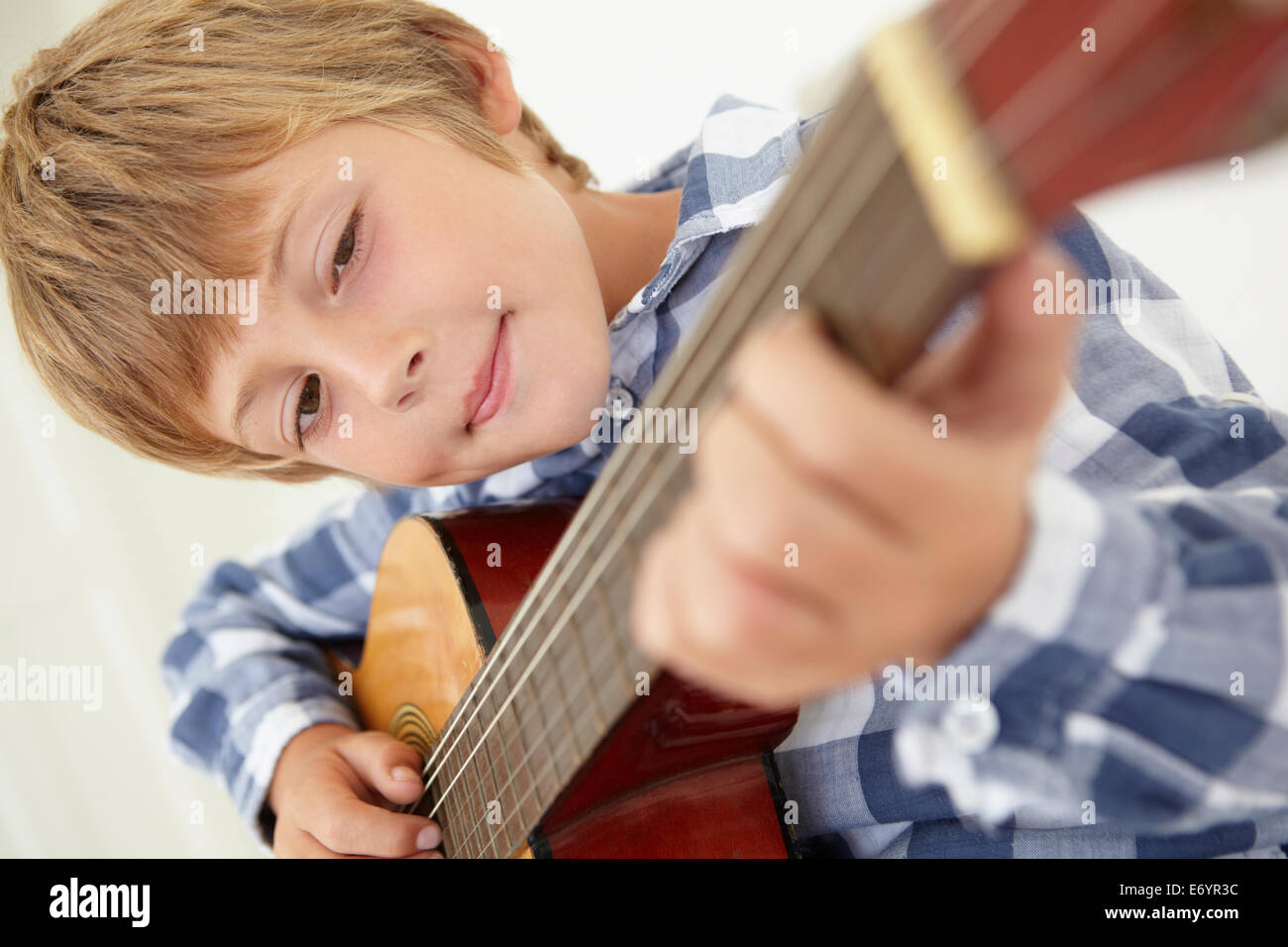 Kleiner Junge spielt akustische Gitarre Stockfoto