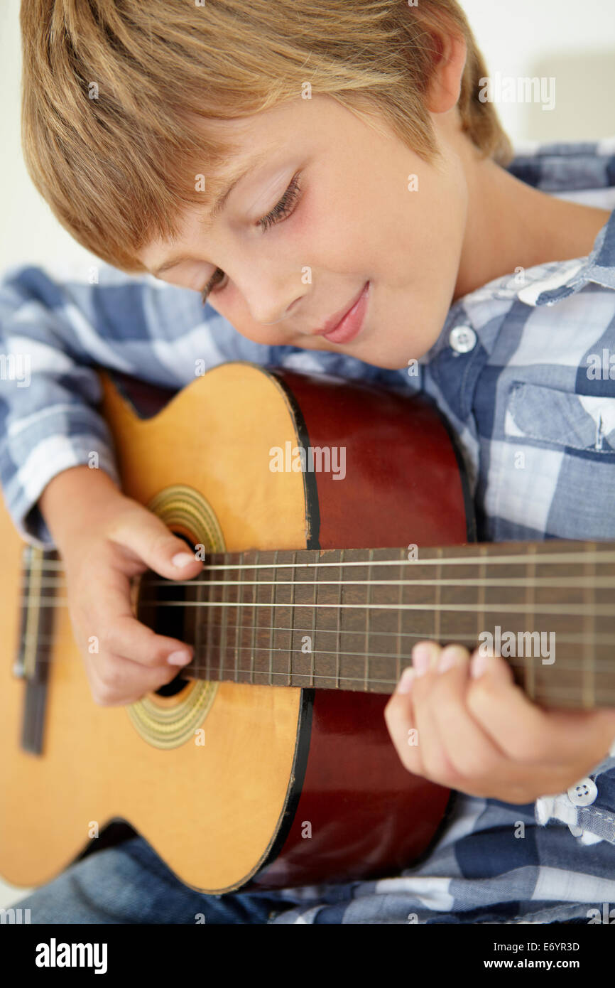 Kleiner Junge spielt akustische Gitarre Stockfoto