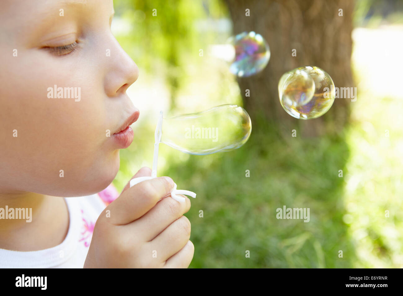 Kleines Mädchen bläst Luftblasen im freien Stockfoto