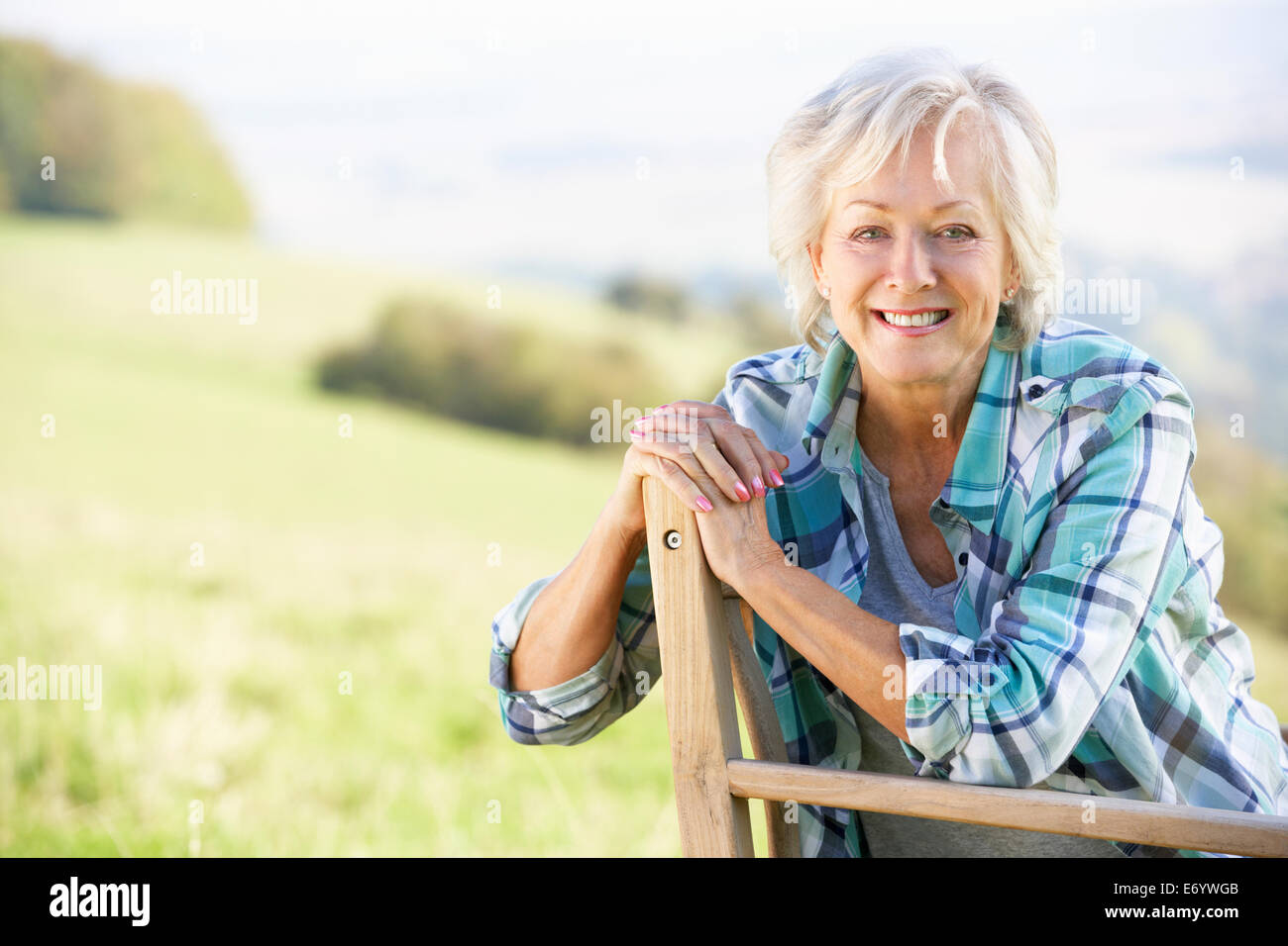 Ältere Frau sitzt im freien Stockfoto