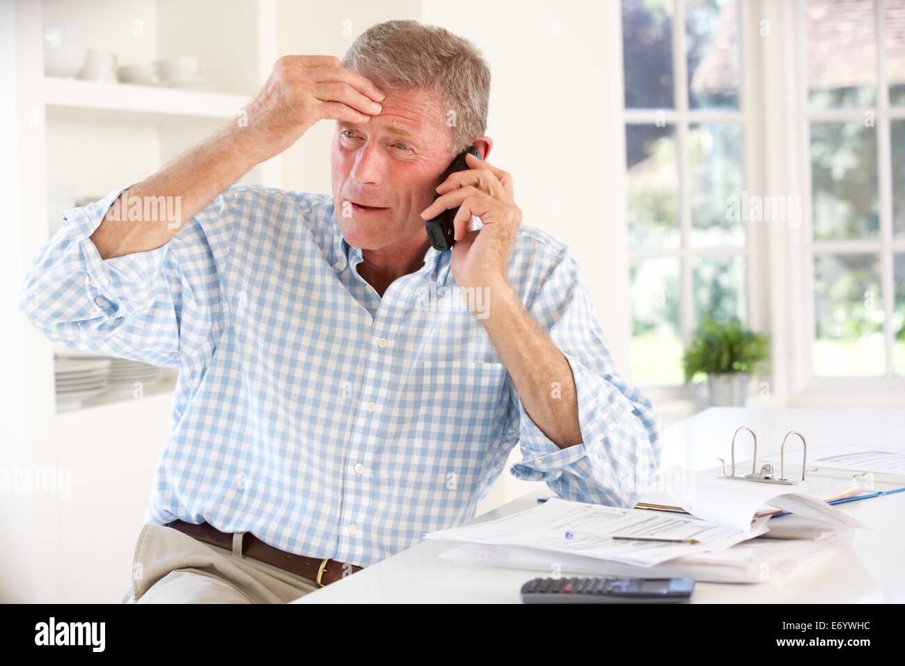 Pensionierter Mann mit Haushaltsrechnungen Stockfoto