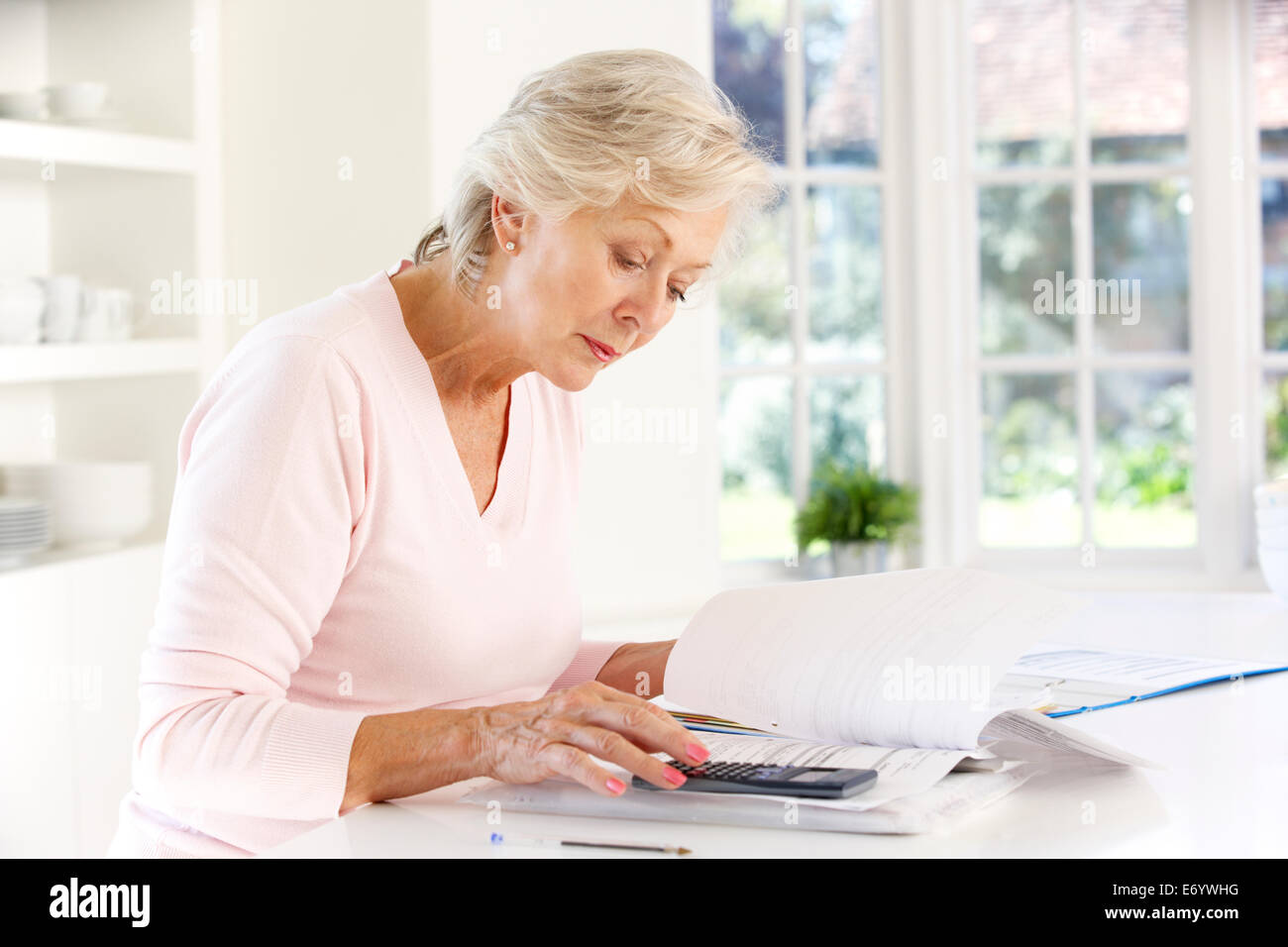 Pensionierte Frau mit Haushaltsrechnungen Stockfoto