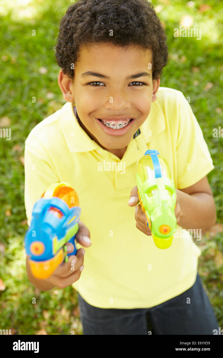 Junge im Park mit Wasserpistolen Stockfoto