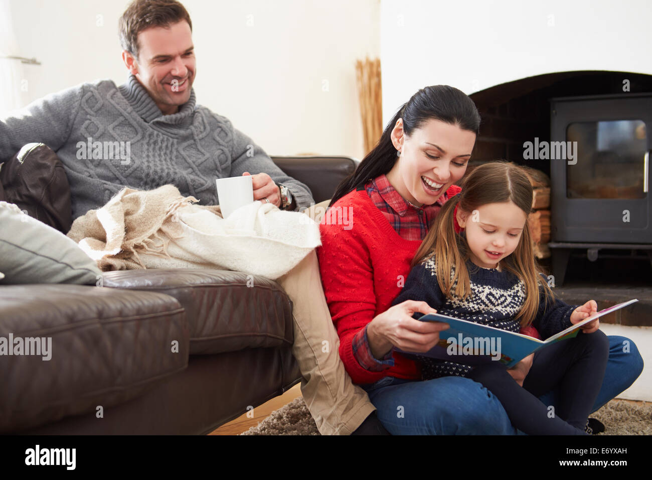 Familie drinnen entspannen und Buch Stockfoto