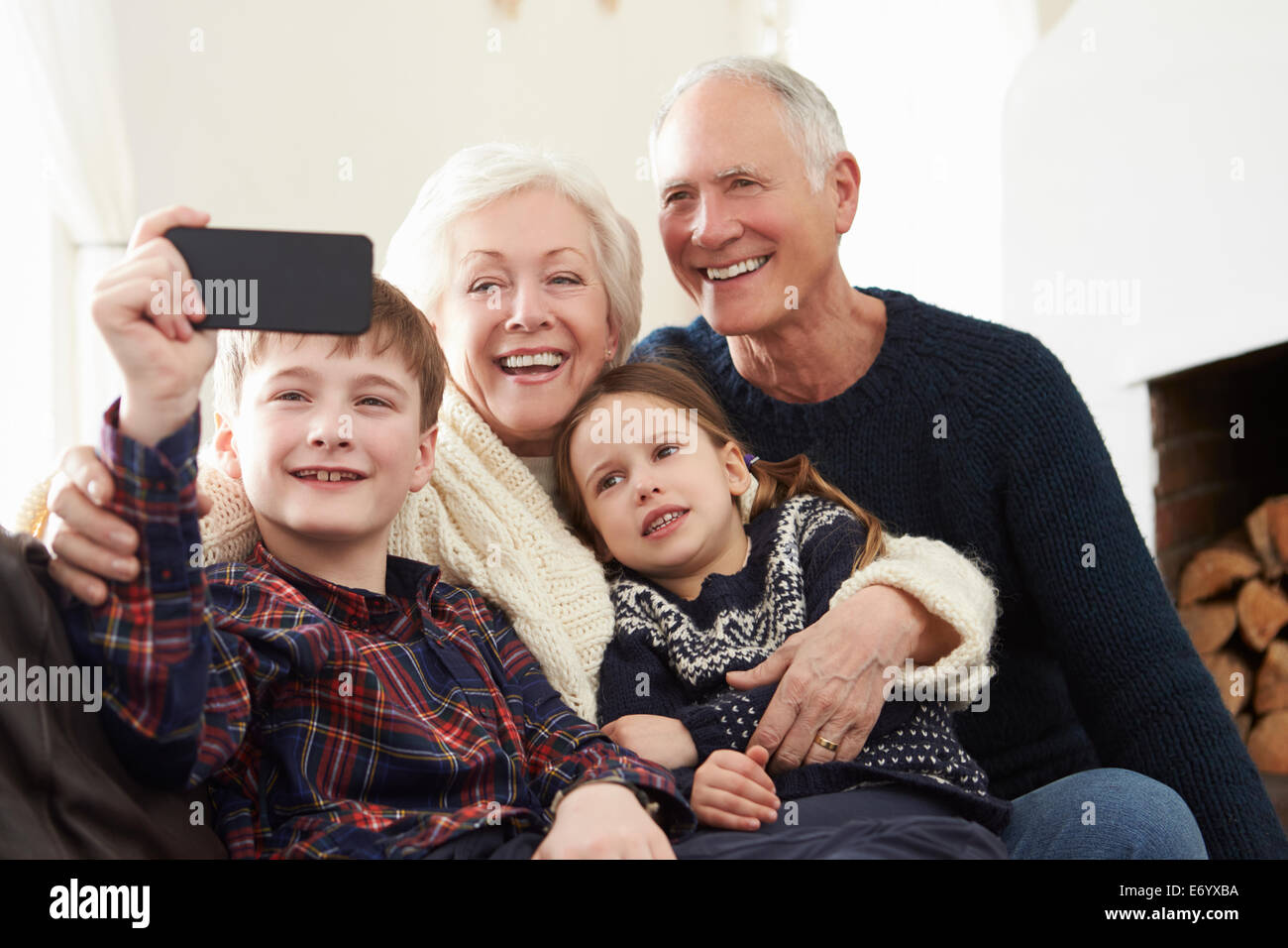 Großeltern und Enkelkinder auf Sofa nehmen Selfie Stockfoto