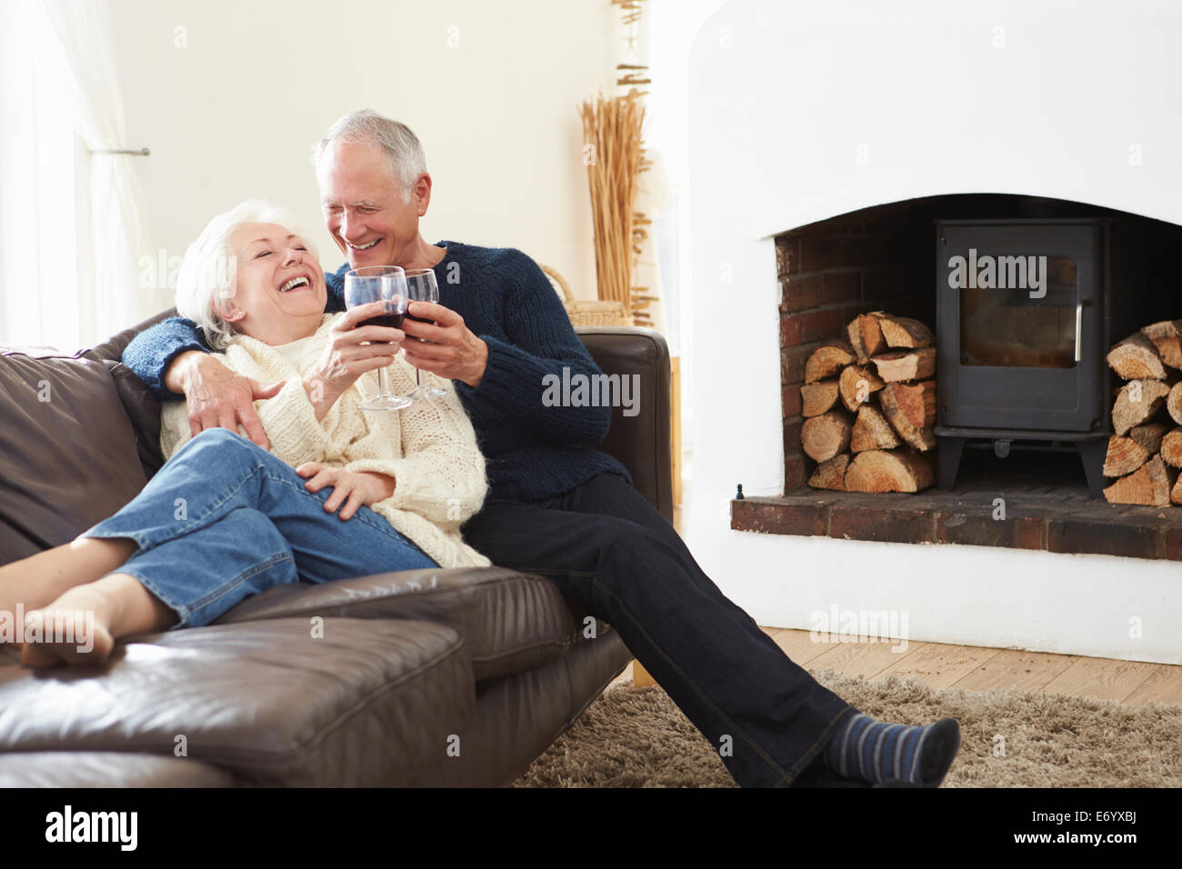 Älteres Paar auf Sofa Rotwein trinken Stockfoto