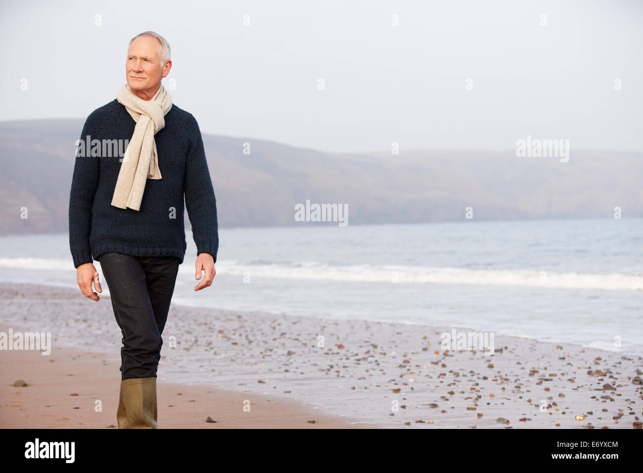 Senior woman Winter Strand entlang spazieren Stockfoto