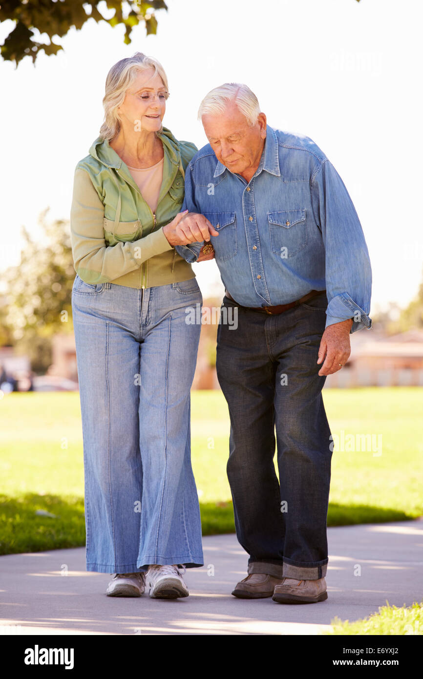 Ältere Frau Mann zu helfen, als sie zusammen im Park Fuß Stockfoto