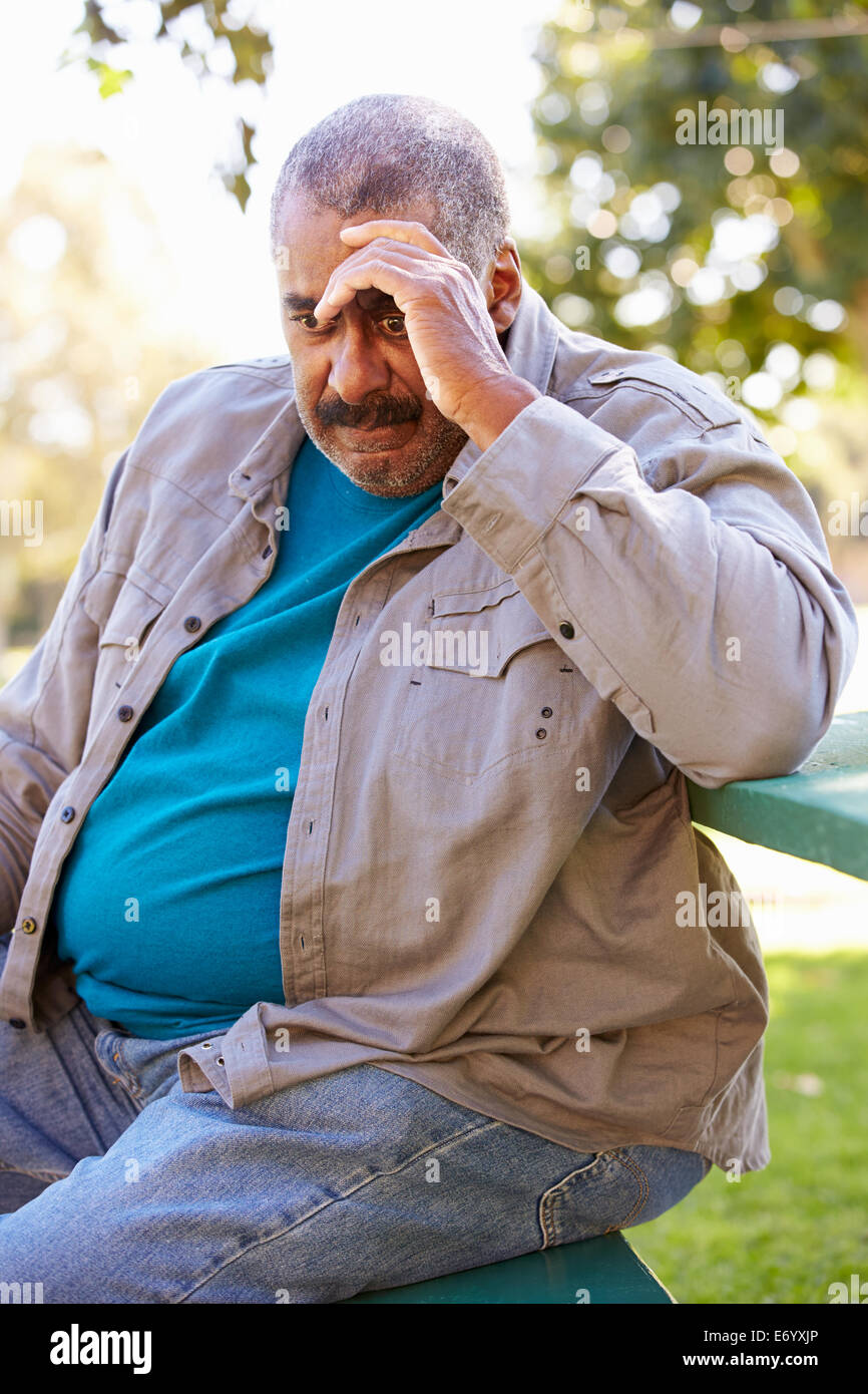 Deprimiert Senior woman, draußen zu sitzen Stockfoto