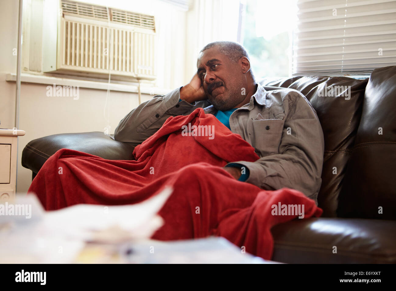 Ältere Mann versucht zu Hause unter Decke Warm zu halten Stockfoto
