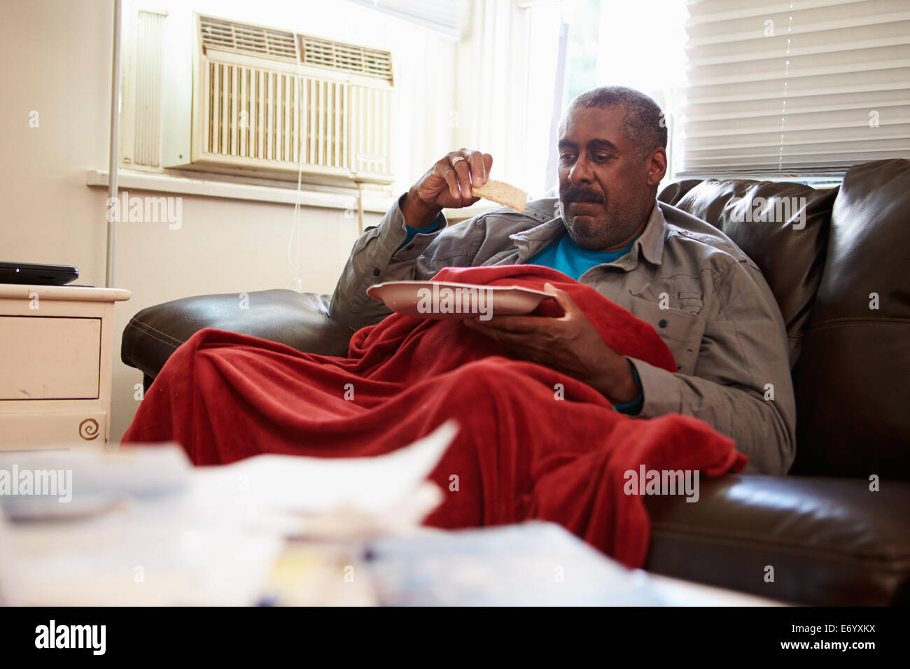 Ältere Mann mit schlechter Ernährung unter Decke Warm zu halten Stockfoto