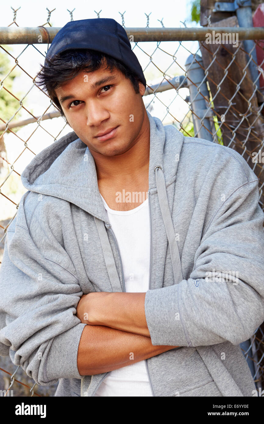 Porträt des Jünglings im städtischen Umfeld durch Zaun stehen Stockfoto